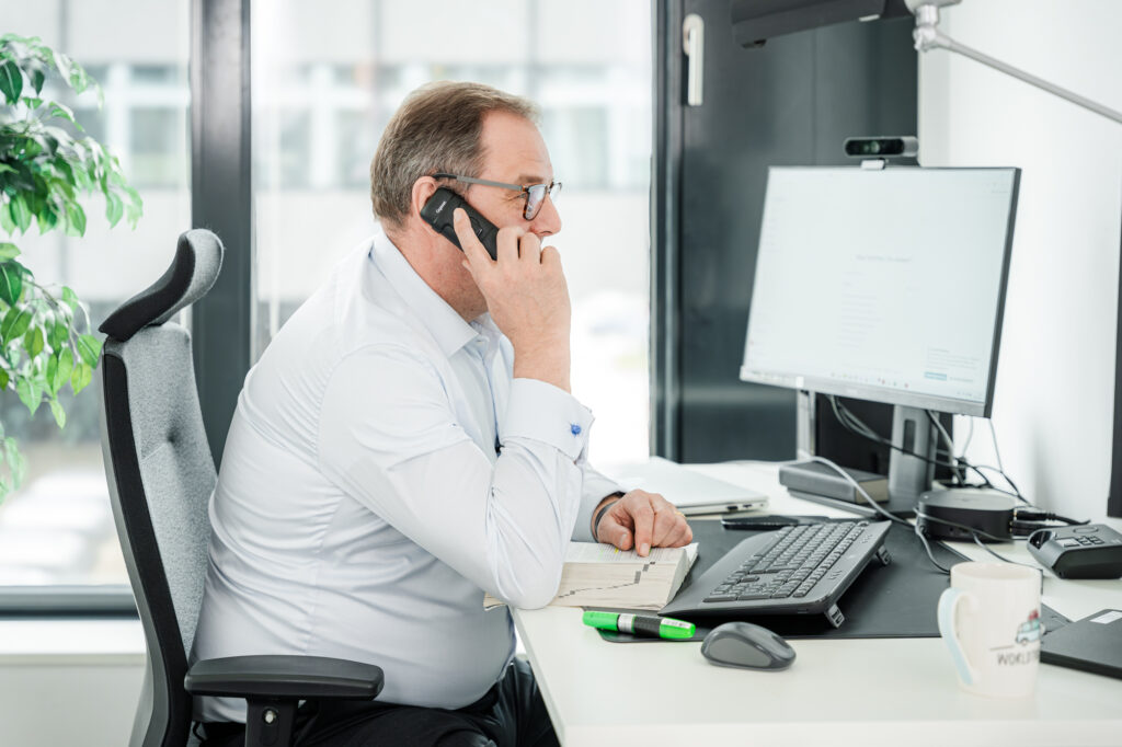 Steuerberater der Jens Briese Steuerberatung im Büro bei einem Telefonat und der Arbeit am Computer – Experte für Steuerberatung, Finanzbuchhaltung und Unternehmensberatung